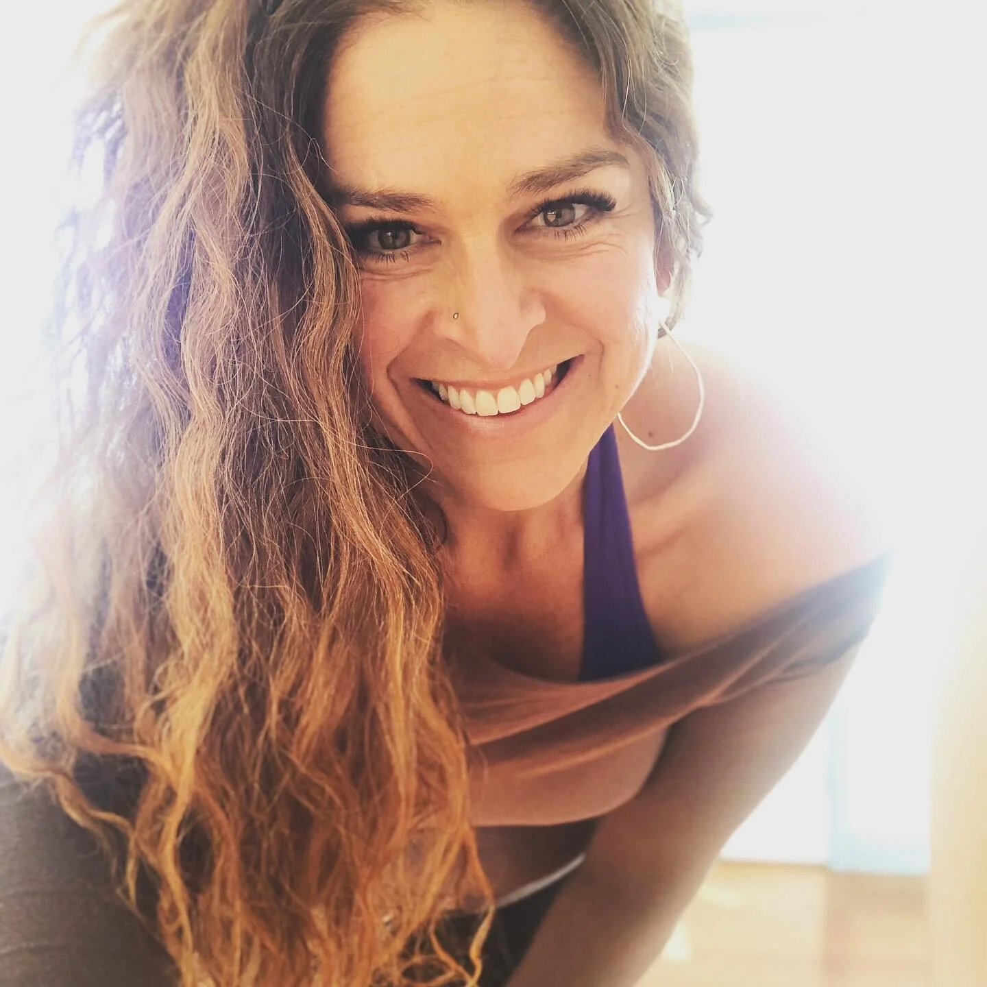 Rebecca leaning in with a warm smile during a session